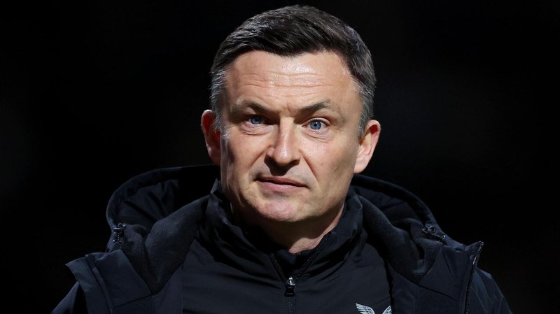 Preston boss Paul Heckingbottom, wearing a black jacket, has a stern look on his face while on the touchline at a game