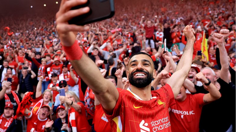 Liverpool forward Mohamed Salah poses for a selfie in front of Liverpool fans after the club win the 2024-25 Premier League title