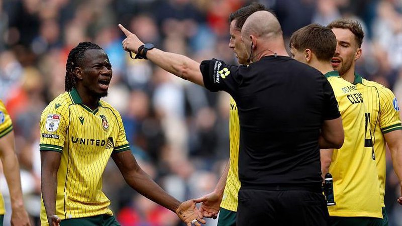 Wrexham's Issa Kabore (left) protests with referee Robert Madley