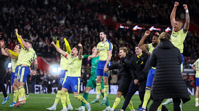 Southampton players celebrate, with arms raised and leaping into the air