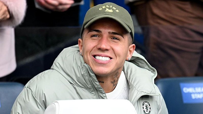 Enzo Fernandez smiling while in sat down in a Chelsea jacket
