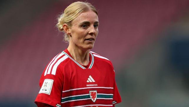 Sophie Ingle on the pitch wearing the red number 4 jersey of Wales.