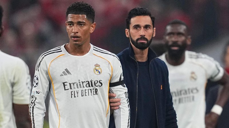 Real Madrid's Jude Bellingham is held back by manager Alvaro Arbeloa after they are knocked out of the Champions League by Bayern Munich