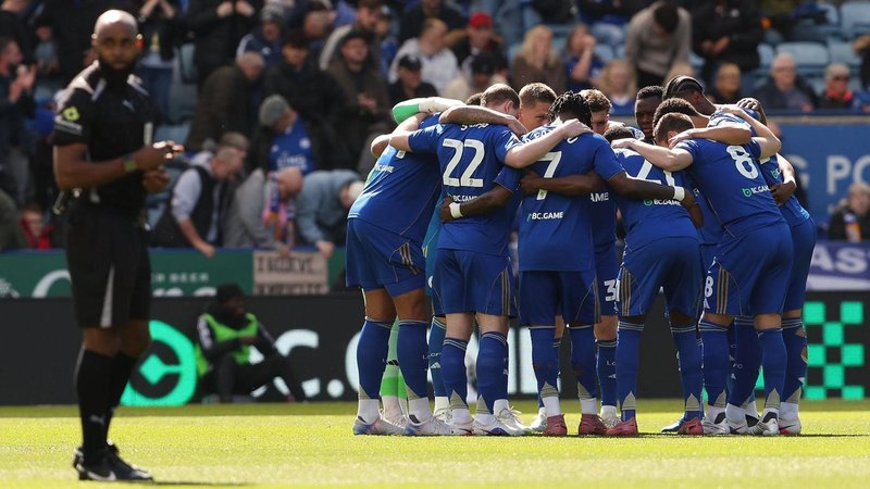 Leicester City players in a huddle on the pitch