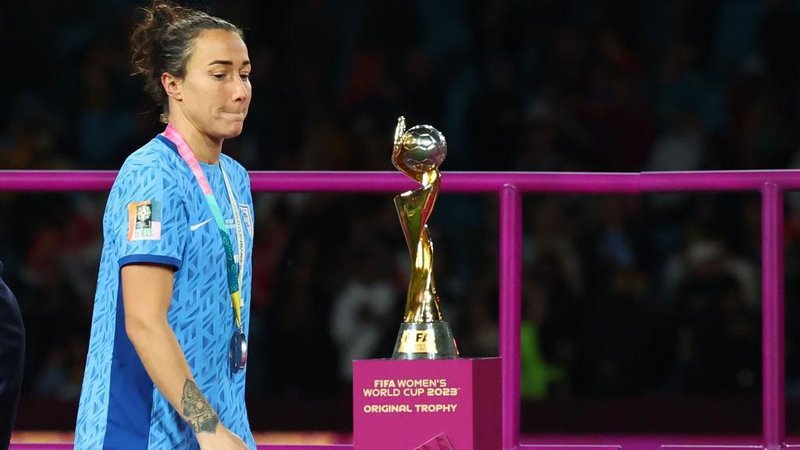 Lucy Bronze walks past the World Cup trophy after picking up her runners-up medal