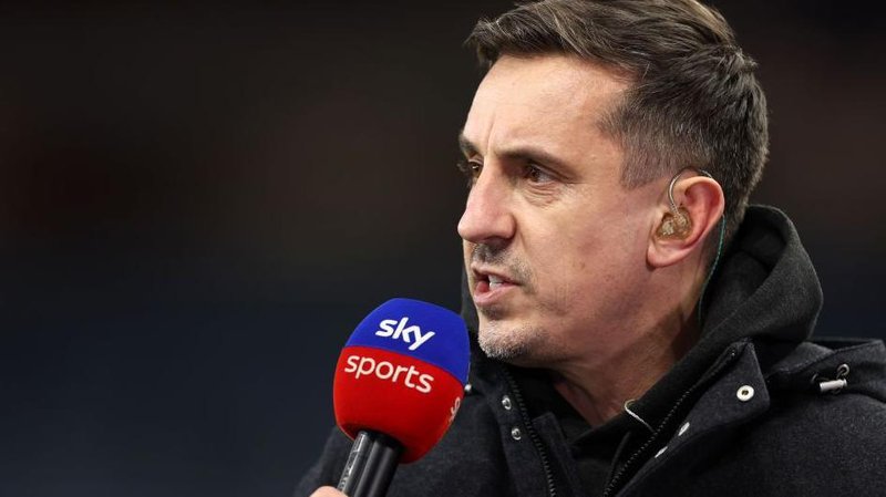 Gary Neville holding a Sky Sports-branded microphone