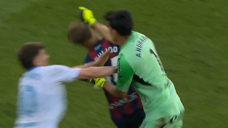 Real Zaragoza goalkeeper Esteban Andrada punches Huesca captain Jorge Pulido