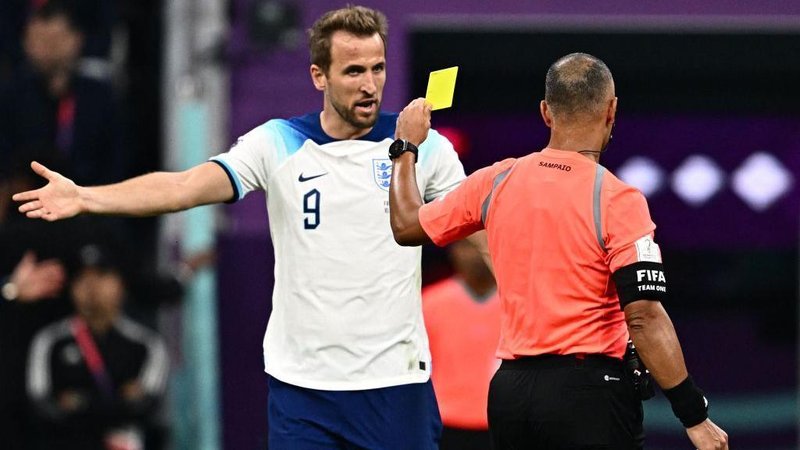 Harry Kane argues with Brazilian referee Wilton Sampaio as he shows a yellow card