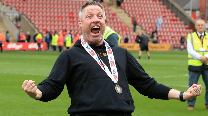 Cambridge United boss Neil Harris celebrates winning promotion to League One after their goalless draw with Crewe.