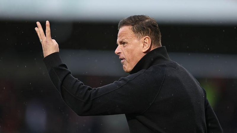 An angry-looking Richie Wellens holds three fingers up at his Orient players from the touchline