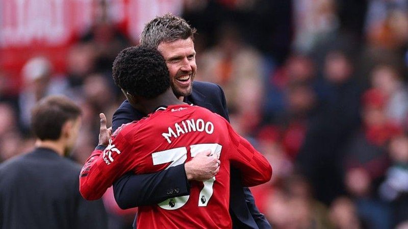 Manchester United manager Michael Carrick and Kobbie Mainoo hug
