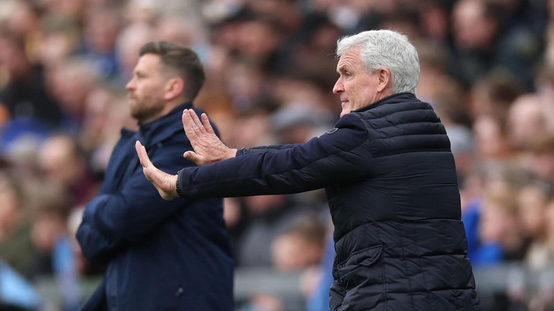 Mark Hughes making a pushing gesture with his two hands while Boreham Wood boss Luke Garrard is in the distance