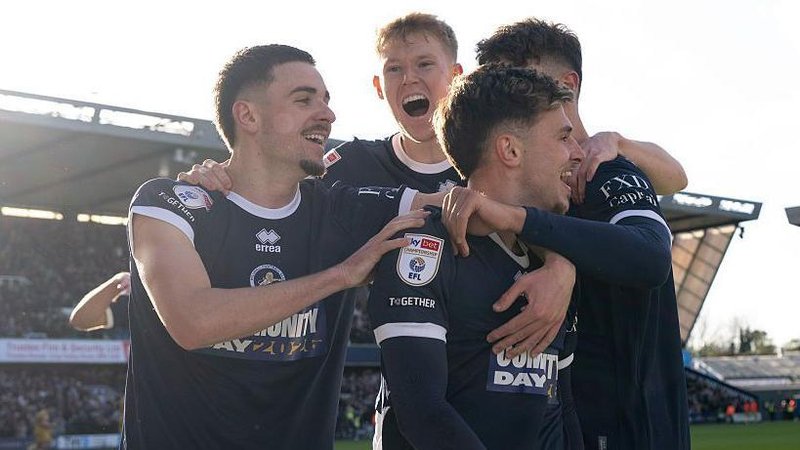 Millwall players celebrate in a huddle