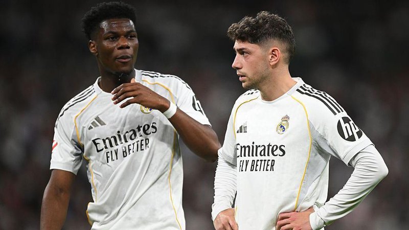 Real Madrid's Aurelien Tchouameni and Federico Valverde stand next to each other in a match, wearing the club's white kit