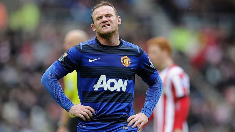 Wayne Rooney grimaces with his hands on his hips