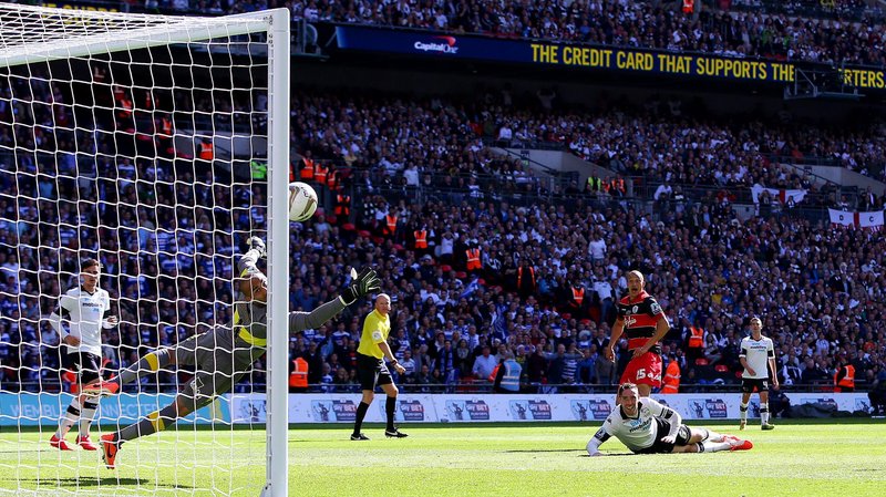 Bobby Zamora in a black and red hooped QPR shirt watches his shot curl around a diving Derby goalkeeper