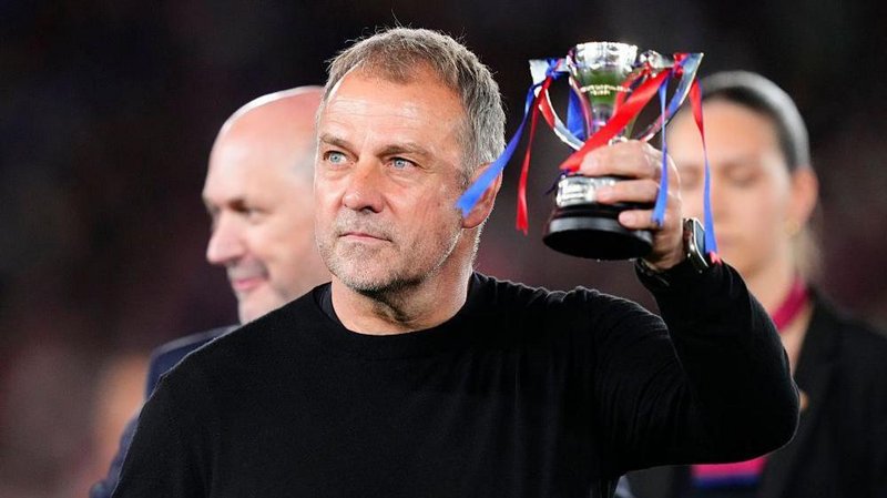 Barcelona coach Hansi Flick lifts a trophy