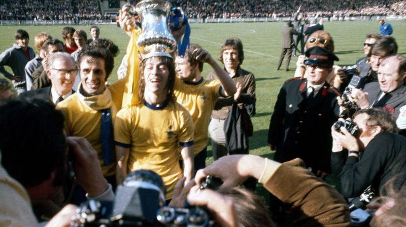 Charlie George with the FA Cup trophy on his head