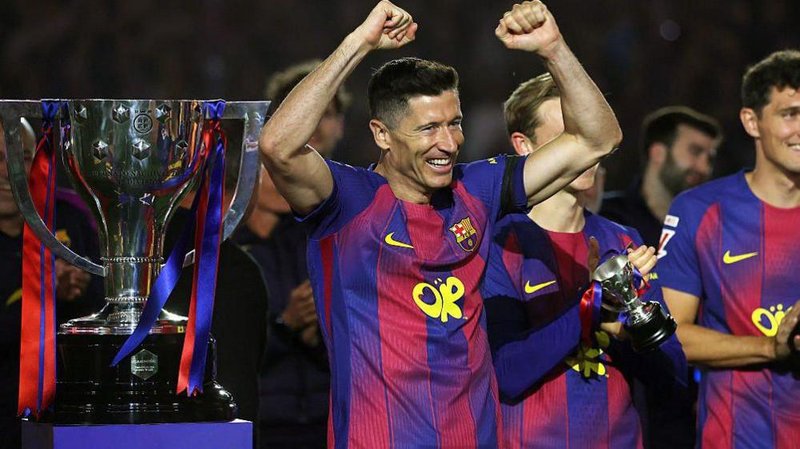 Robert Lewandowski celebrating next to the Liga trophy.