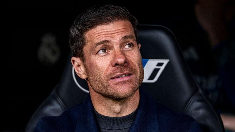 Xabi Alonso smiling while sat in the Real Madrid dugout