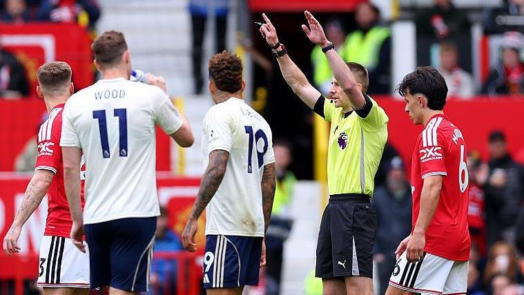 Referee Michael Salisbury signals before he awards a second goal to Matheus Cunha of Manchester United after a VAR check