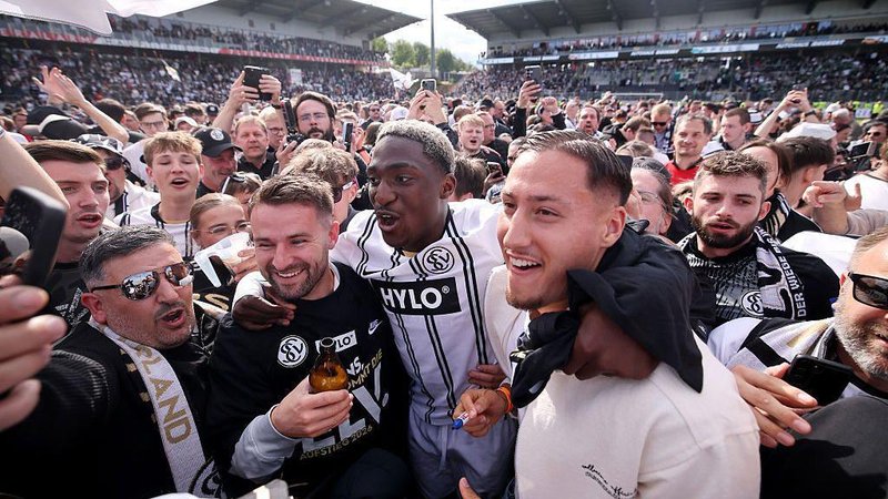 Elversberg players and supporters celebrate on the pitch