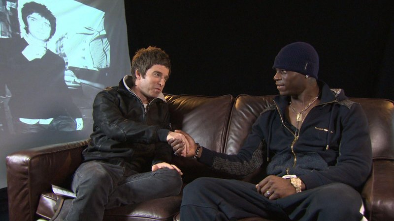 A picture of Noel Gallagher sitting on a sofa with Mario Balotelli