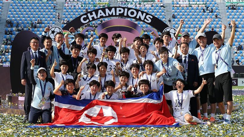 Naegohyang pose for a team photo with the North Korean flag
