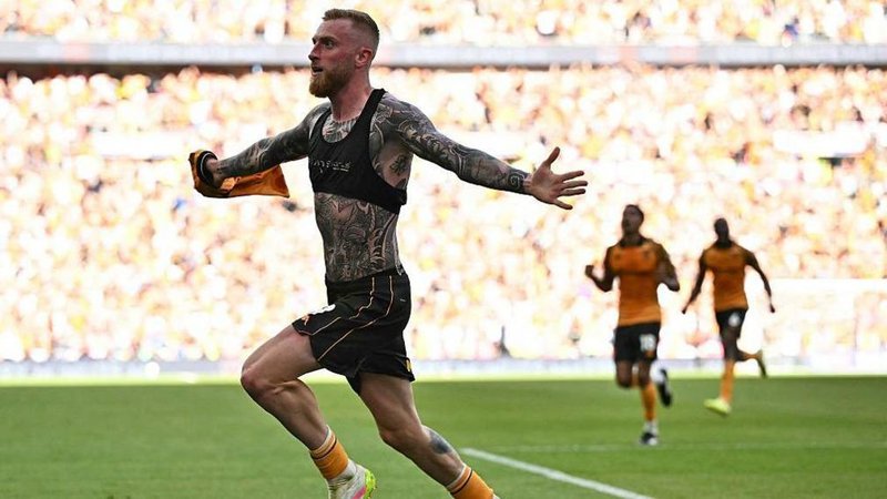 Hull City strike Oli McBurnie with his shirt off showing a torso and arms covered in tattoos runs away to celebrate his winnin goal against Middlesbrough